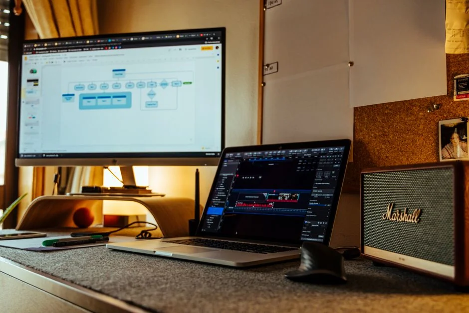 A clean desk arrangement with two monitors, a keyboard, mouse, and notebook, set up for productive work.